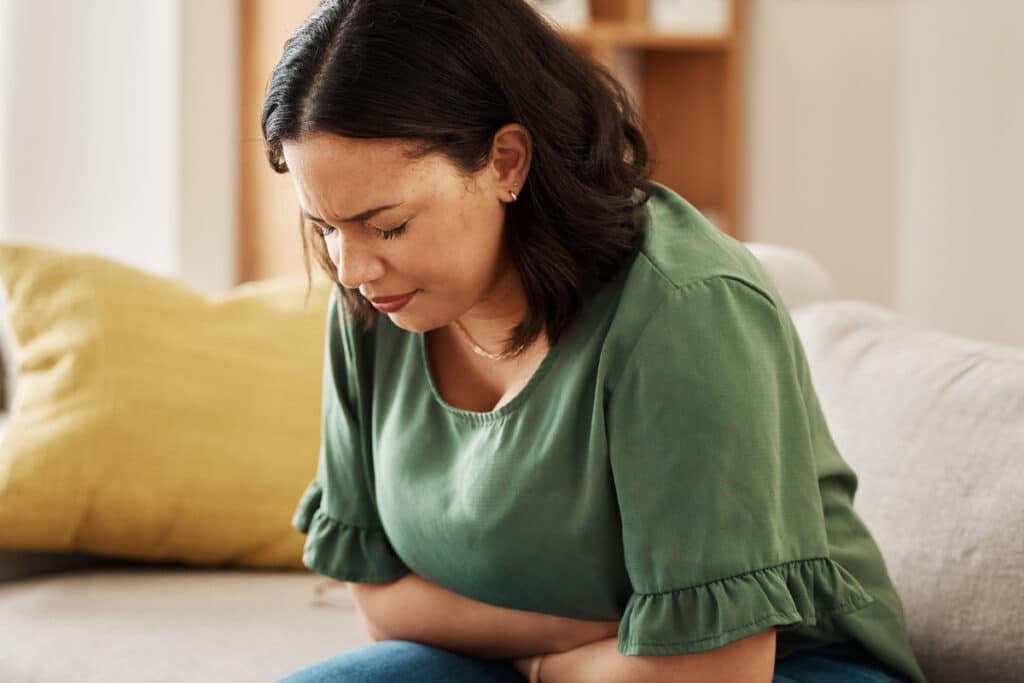 Woman with bloating and abdominal pain linked to gut health and thyroid function