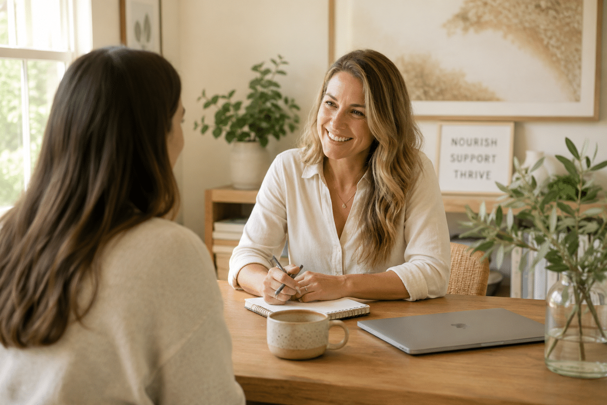 Smiling functional nutrition practitioner meeting with a client in a supportive consultation, discussing practical and simplified approaches to improving health and nutrition without overcomplication.